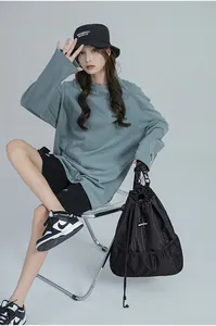 Sac seau en toile noire minimaliste porté dans un look streetwear tendance et moderne