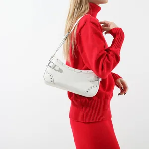 Sac à bandoulière blanc en similicuir avec clous argentés et boucle sur pull rouge