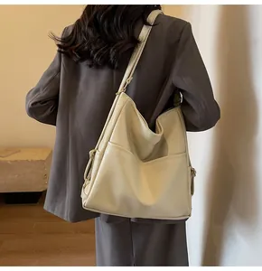 Detail of a large beige PU leather bucket bag with a soft lychee texture and side pockets