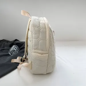 Quilted cream nylon backpack with soft cloud pattern and side pocket view
