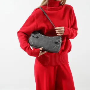 Sac baguette en denim gris foncé avec clous argentés porté avec une tenue rouge