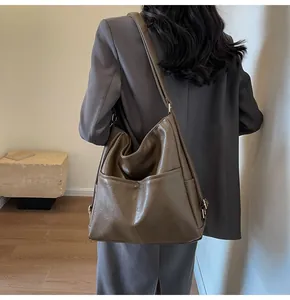 Detail view of large dark brown PU leather tote bag with vintage metal buckle and side pocket