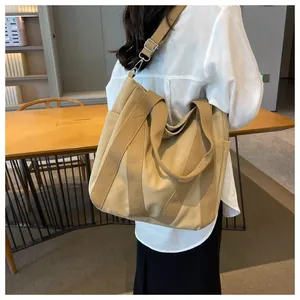 Detailed side view of khaki canvas tote bag worn by a model for daily commuting