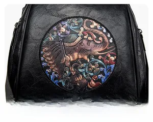 Close-up of black litchi grain leather backpack with ethnic elephant embossed pattern
