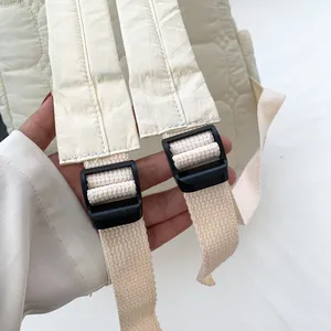 Quilted cream puffer backpack with adjustable shoulder straps and floral stitching