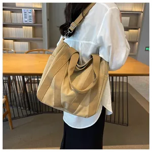 Detail of khaki canvas tote bag showing side pocket and adjustable strap for commuting