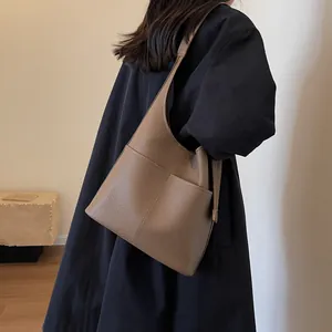 Brown litchi grain leather hobo shoulder bag for women shown in a lifestyle commuter scene