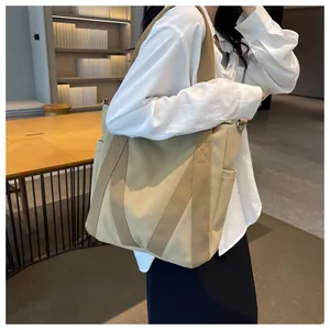 Detailed view of khaki canvas tote bag featuring side pockets and reinforced webbing straps