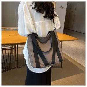 Back view of model wearing a large canvas tote bag with side pocket and strap details