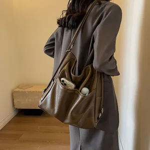 Large dark brown vintage leather tote bag with side pockets and shoulder strap