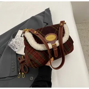 Detailed macro view of the vintage plaid wool shoulder bag with plush trim and gold logo plate