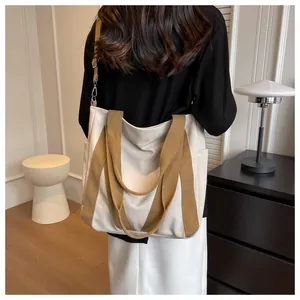 Detailed back view of a minimalist cream and brown large canvas tote bag with woven strap