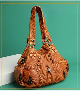 Close-up of brown vintage handbag featuring metal heart studs and textured synthetic leather