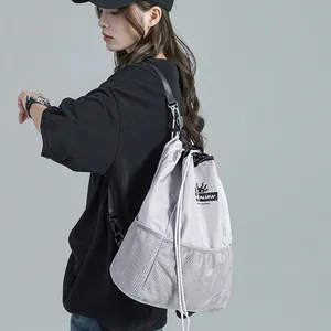 Sac à dos gris clair à cordon avec poche en filet et bretelles réglables, vue de style décontracté