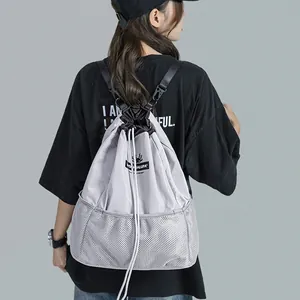 Sac à dos polyvalent en nylon gris avec cordon de serrage et empiècements en mesh