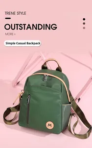 Primer plano de una mochila de nailon verde con parche redondo M y elegantes asas de cuero