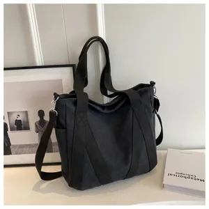 Detail of high-density black canvas tote bag with adjustable strap and side pockets