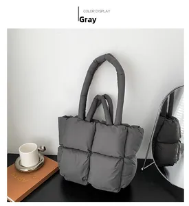 Detailed view of gray quilted puffer tote bag on a black table with minimalist decor
