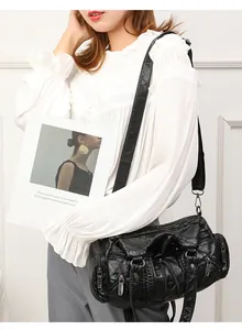 Detail of vintage-style black washed leather bag with zip pockets and pleated texture