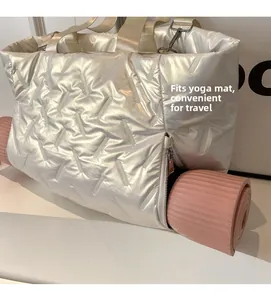 Quilted silver gym bag showing the bottom zipper compartment storing a pink yoga mat