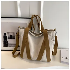 Detail view of large canvas tote bag showing thick beige fabric and khaki shoulder straps