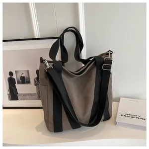 Close-up of large canvas tote bag with black strap and metallic buckle detail