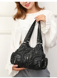 Detail of vintage black faux leather tote featuring multi-pockets and rivet accents