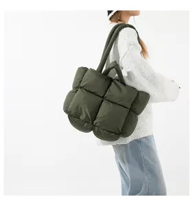 Detail view of large olive green quilted puffer tote bag with thick shoulder straps