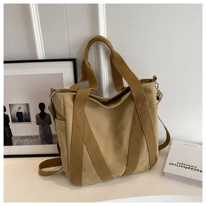 Close-up of khaki canvas tote bag featuring adjustable strap and metallic hardware details