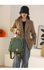 Detalle de mochila de nailon verde fruta impermeable con parche M y correas oliva