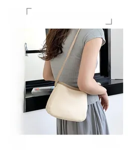 Vue détaillée du sac seau beige montrant la texture litchi et la finition brune