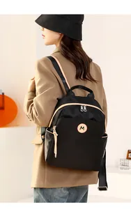 Close-up of lightweight oxford fabric backpack with stylish contrast trim and M-logo patch