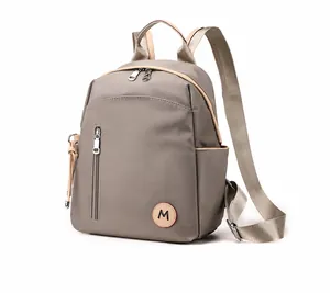 Mochila gris de nailon impermeable con bolsillo vertical de cremallera en vista lateral 45°