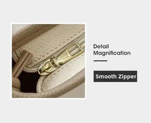 Gros plan sur la fermeture éclair dorée fluide du sac seau en cuir beige grainé