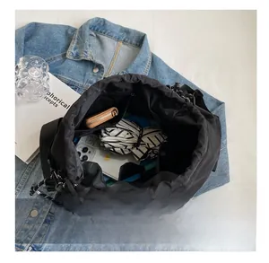 Interior view of black drawstring bucket bag showing large capacity with personal items