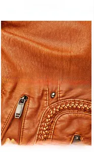 Detailed view of vintage brown leather texture with metallic zippers and woven trim