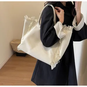 Détail d'un grand sac cabas en toile avec des accents de franges et des anses solides