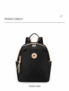 Detail of waterproof oxford cloth backpack with brown leather trim and M logo patch