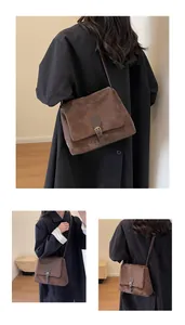 Detail of dark brown retro messenger bag with matte leather texture and bronze buckle