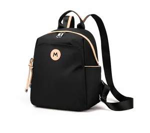 Detail view of black oxford fabric backpack featuring beige trim and stylish side pocket