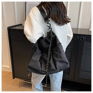 Detailed back view of a black large capacity nylon shoulder bag with drawstring detail