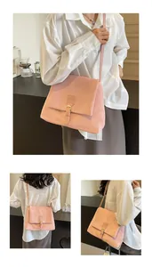 Detail of pink faux leather messenger bag with fine texture and slim strap buckle