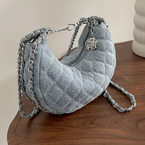 Bolso media luna de mezclilla azul claro con acolchado de rombos y cadena plateada