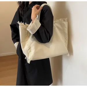 Détail d'un sac cabas en toile avec bords à franges élégants et design crème minimaliste
