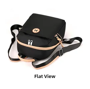 Close-up of lightweight black nylon backpack with brown trim and dual zipper detail