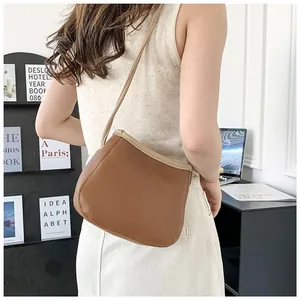 Gros plan du sac seau bicolore porté par un mannequin dans un bureau minimaliste