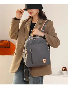 Detalle de la mochila de nailon impermeable en gris oscuro con bolsillos y cremallera