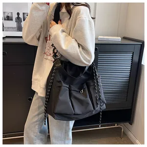 Detail of black nylon crossbody bag with multi-pocket design and striped drawstrings