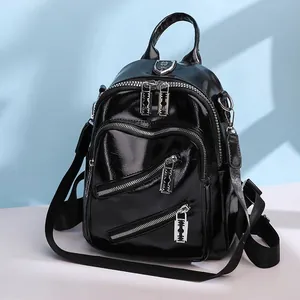 Détail du sac à dos en cuir PU noir brillant avec tirettes de fermeture argentées