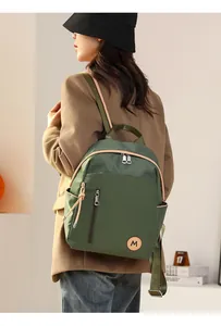 Vista trasera de una modelo con la mochila de nailon impermeable verde oscuro moderna